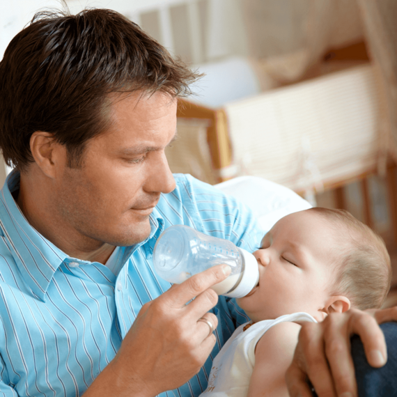 Vater füttert Baby